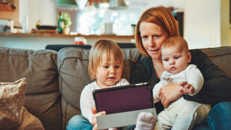 A parent and child drawing tarot cards together at a kitchen table, showing how tarot can be used for family guidance, parenting reflection and emotional self-care